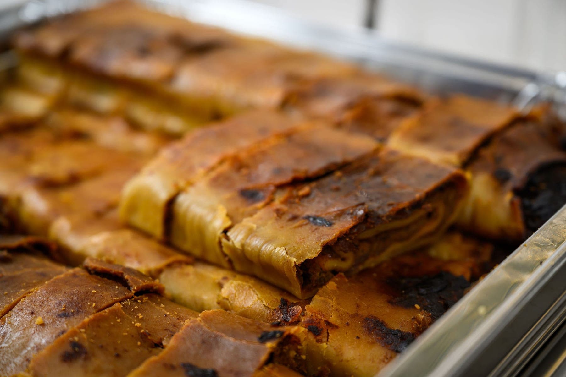 Layered potato kugel, cut and served in a tray